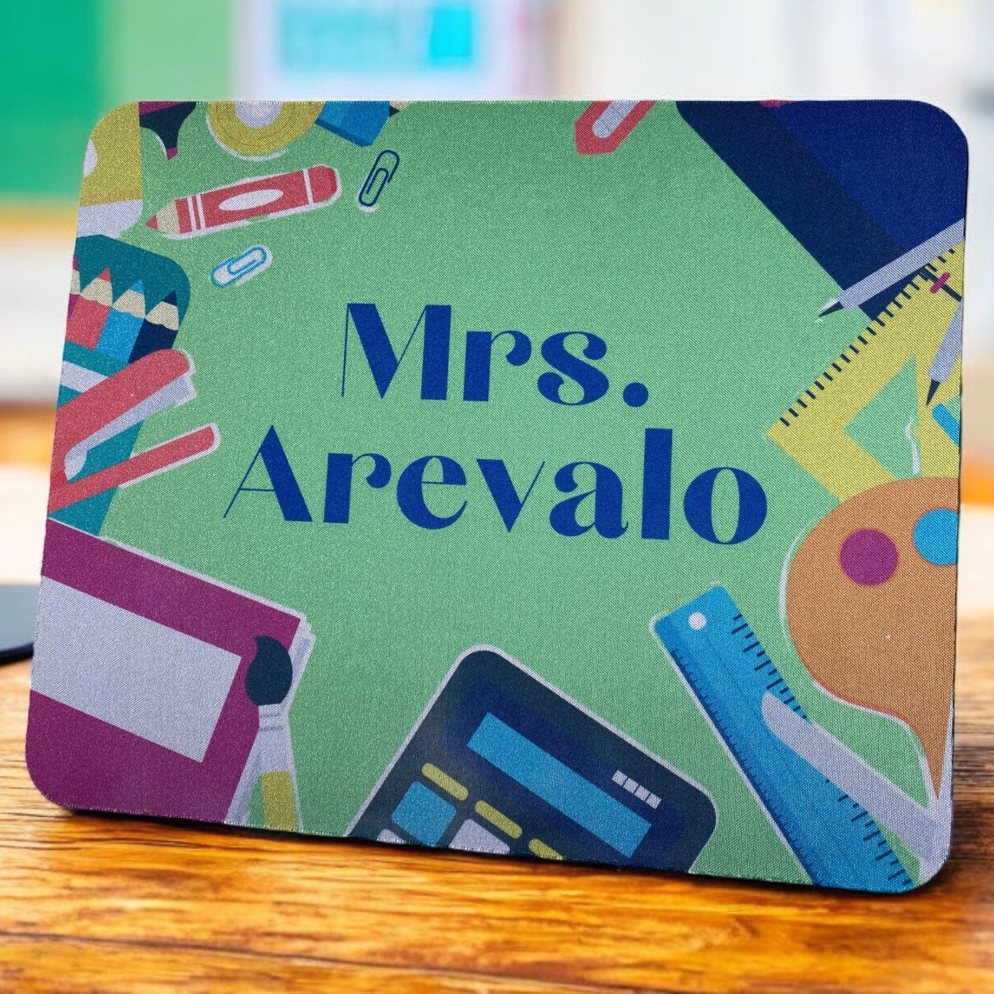 A colorful mousepad with the text 'MR.S MINTZ' in bold letters, surrounded by various candy shapes and graphics on a pink background.