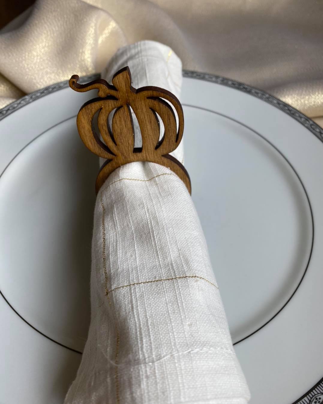 Graceful Creations by Graciela handcrafted wooden pumpkin napkin ring on a white linen napkin and dinner plate